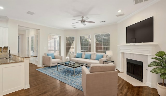 living area with visible vents, crown molding, and light wood-style flooring