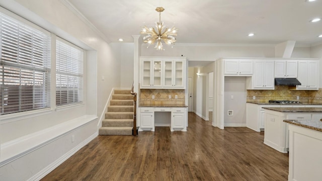 kitchen featuring dark wood-style floors, hanging light fixtures, glass insert cabinets, white cabinetry, and dark stone counters