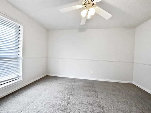 carpeted spare room featuring a ceiling fan and baseboards