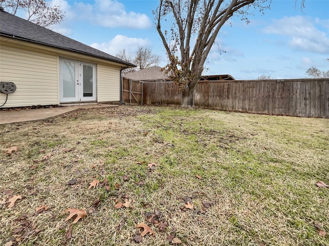 view of yard with french doors and a fenced backyard