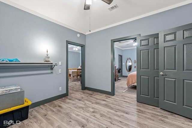 bedroom featuring visible vents, crown molding, light wood-style flooring, and baseboards