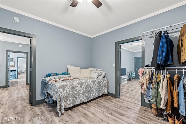 bedroom with crown molding, light wood-style flooring, baseboards, and ceiling fan