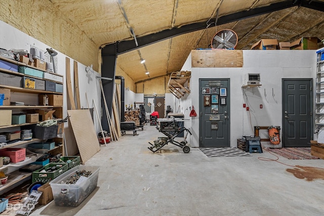 misc room featuring a garage, high vaulted ceiling, and unfinished concrete floors