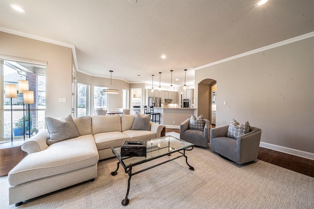 living room featuring arched walkways, light wood-style floors, recessed lighting, and baseboards