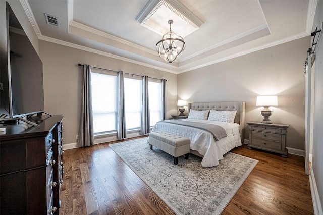 bedroom featuring a tray ceiling, dark wood finished floors, visible vents, an inviting chandelier, and a barn door