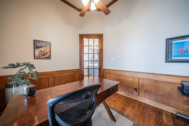 office space with a wainscoted wall, ceiling fan, wood finished floors, and crown molding