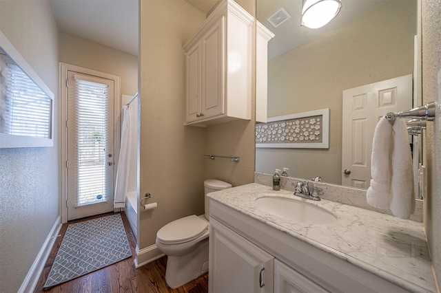 full bath with visible vents, toilet, shower / bath combo, wood finished floors, and baseboards