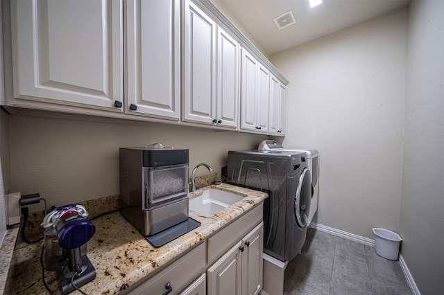 laundry room with a sink, visible vents, baseboards, independent washer and dryer, and cabinet space