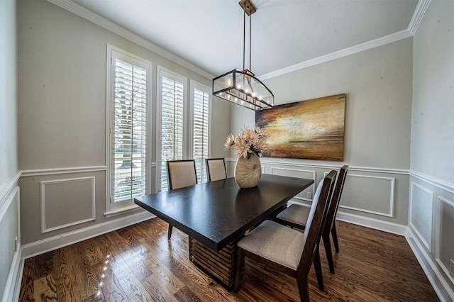 dining area featuring a notable chandelier, crown molding, a decorative wall, and wood finished floors