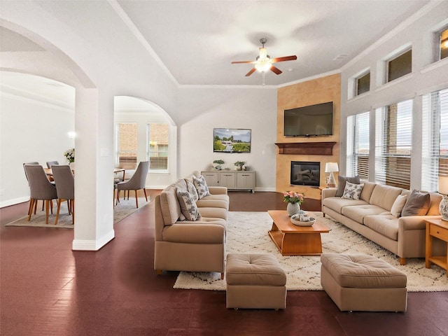 living area with baseboards, arched walkways, dark wood-style flooring, crown molding, and a fireplace