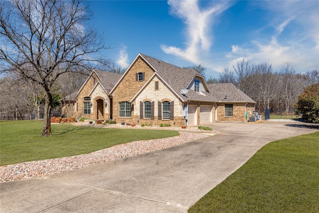 french country inspired facade featuring crawl space, an attached garage, brick siding, and a front lawn