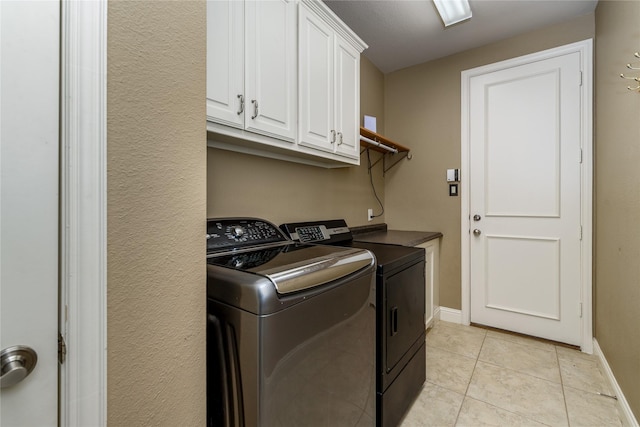 washroom featuring baseboards, cabinet space, independent washer and dryer, and light tile patterned flooring