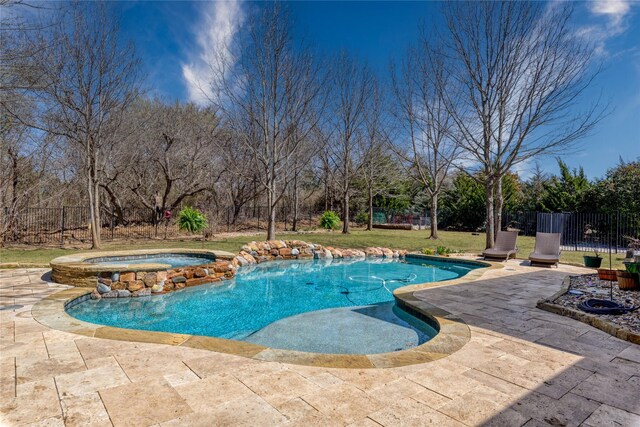 pool with a yard, a patio, an in ground hot tub, and fence