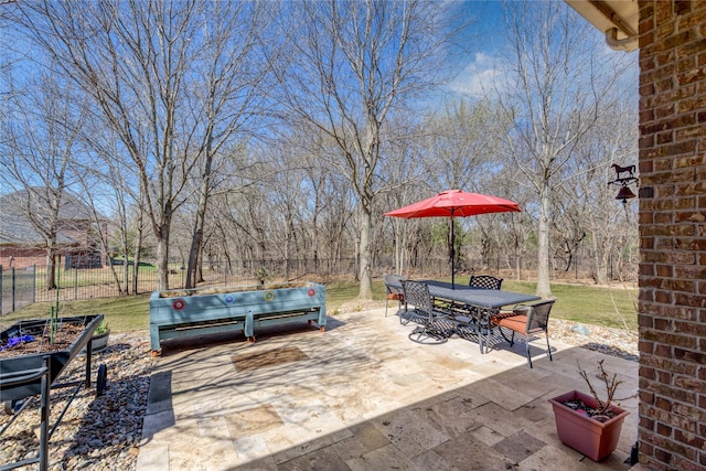 view of patio / terrace with a vegetable garden, outdoor dining area, and fence