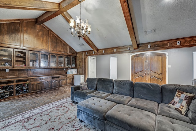 living area with visible vents, lofted ceiling with beams, a textured ceiling, wood walls, and a notable chandelier