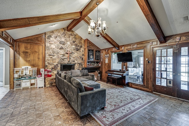 living area with lofted ceiling with beams, tile patterned floors, an inviting chandelier, a textured ceiling, and wood walls