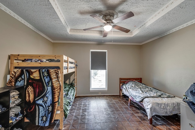 bedroom with a textured ceiling, dark floors, a tray ceiling, and baseboards