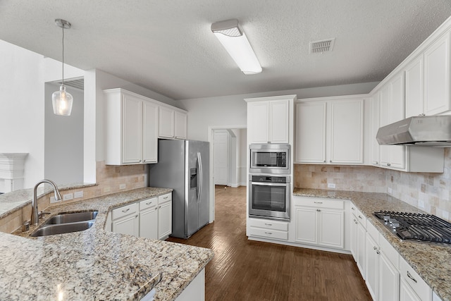 kitchen featuring pendant lighting, stainless steel appliances, white cabinetry, a sink, and under cabinet range hood