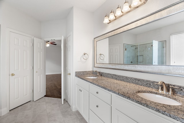 bathroom with double vanity, tile patterned floors, a sink, and a shower stall