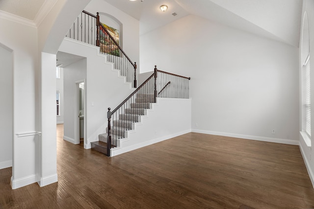 interior space featuring high vaulted ceiling, arched walkways, baseboards, and wood finished floors