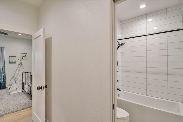 bathroom featuring wood finished floors, shower / tub combination, and toilet