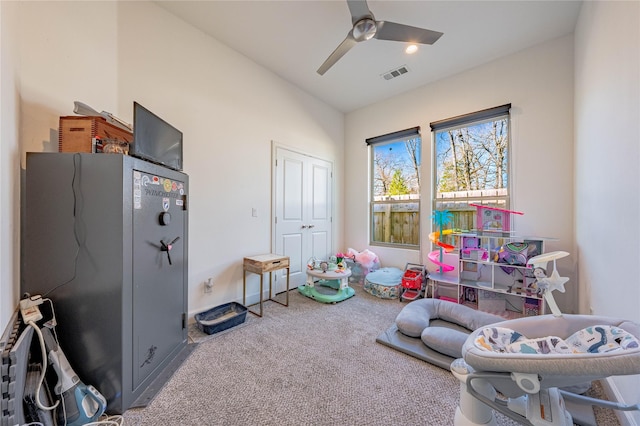 recreation room with carpet floors, ceiling fan, and visible vents