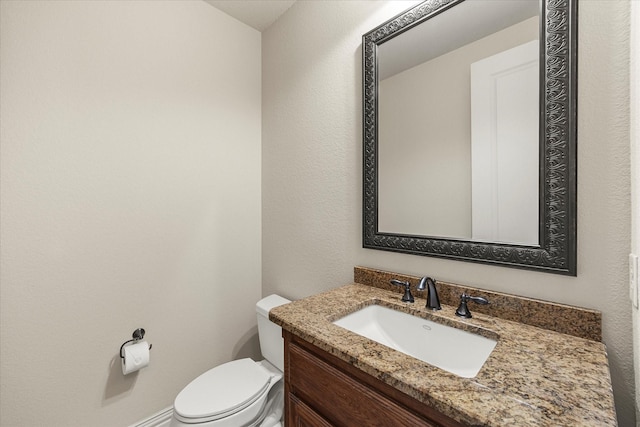 half bathroom featuring toilet and vanity