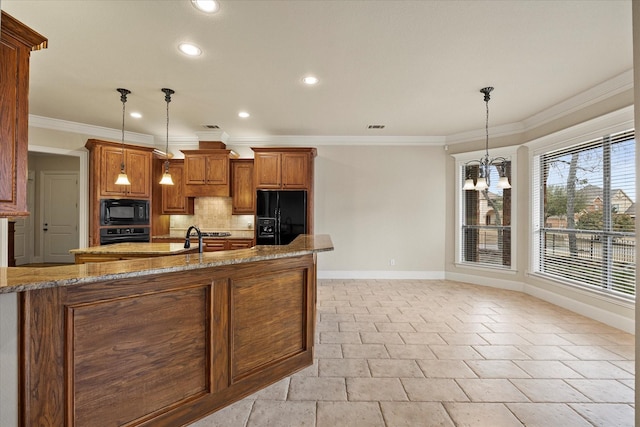 kitchen featuring brown cabinets, decorative light fixtures, decorative backsplash, light stone countertops, and black appliances