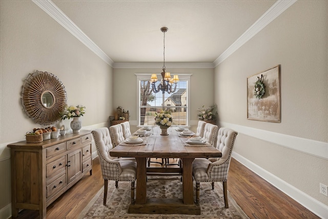 dining area featuring baseboards, an inviting chandelier, wood finished floors, and crown molding