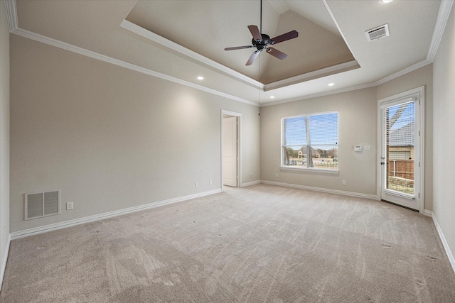 spare room with ornamental molding, a raised ceiling, visible vents, and baseboards