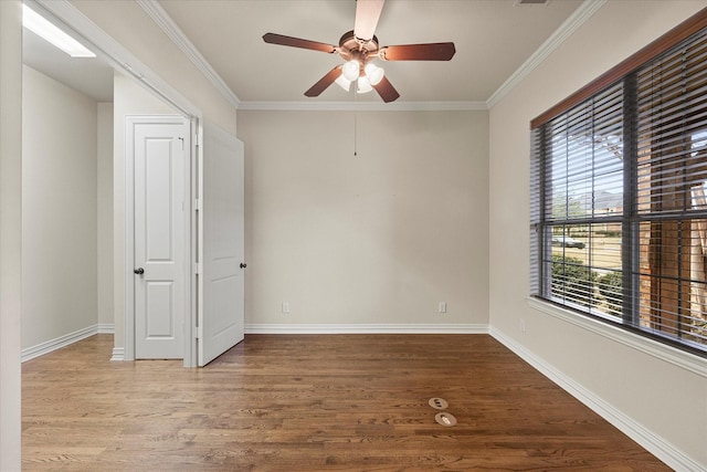 unfurnished room with baseboards, a wealth of natural light, and wood finished floors