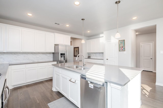 kitchen featuring a center island with sink, visible vents, appliances with stainless steel finishes, white cabinetry, and pendant lighting