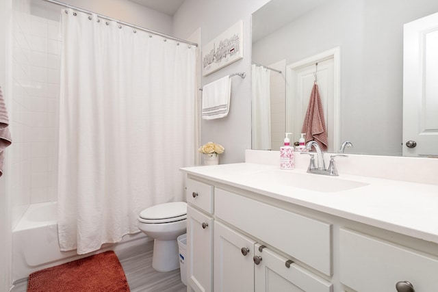 full bathroom featuring vanity, wood finished floors, shower / bath combo with shower curtain, and toilet