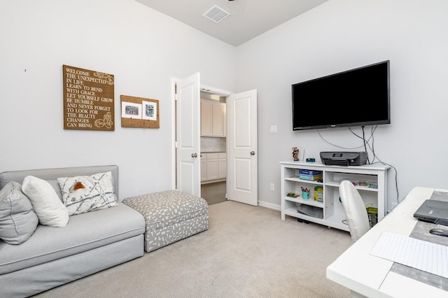 living area with visible vents and light colored carpet