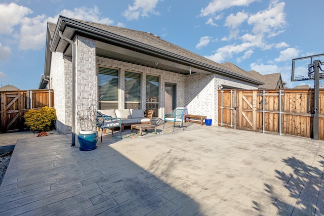 back of property featuring a gate, fence, an outdoor living space, and a wooden deck