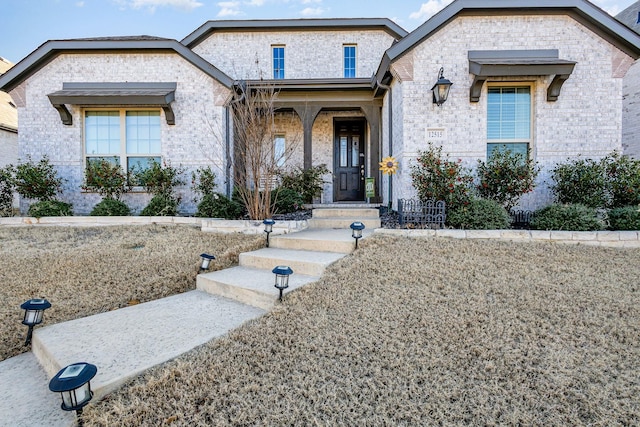 french country style house with brick siding