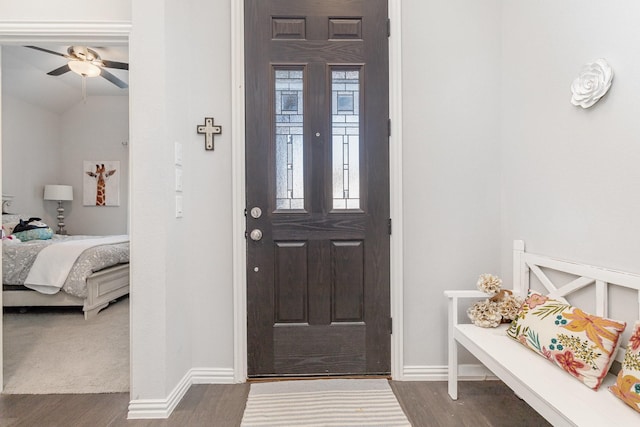 entryway with dark wood-style flooring, ceiling fan, and baseboards