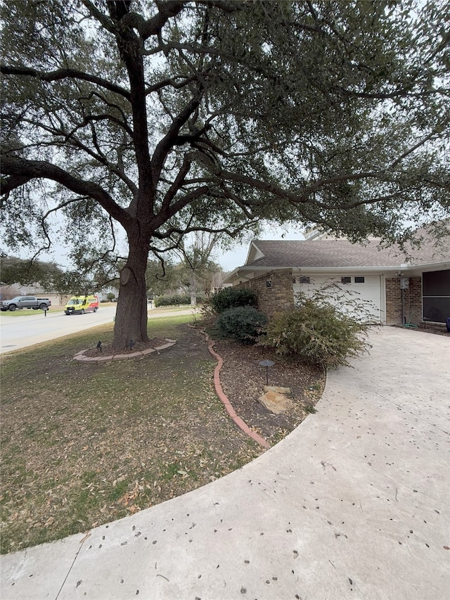 view of side of property with concrete driveway and brick siding