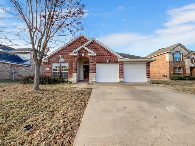 traditional home with a garage, stone siding, driveway, and brick siding