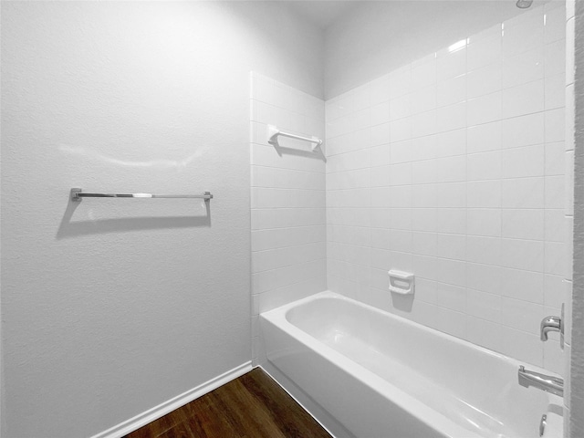 full bath with  shower combination, baseboards, and wood finished floors