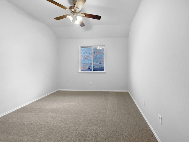 spare room with a ceiling fan, carpet, vaulted ceiling, and baseboards