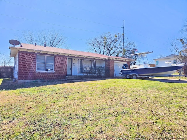 single story home with a garage, a front yard, and brick siding