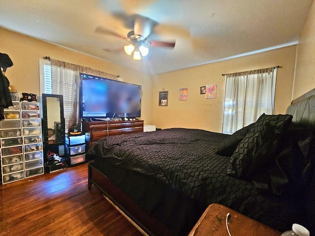 bedroom with dark wood-type flooring, multiple windows, and a ceiling fan