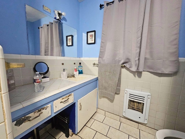 bathroom with tile walls, tile patterned flooring, vanity, and heating unit