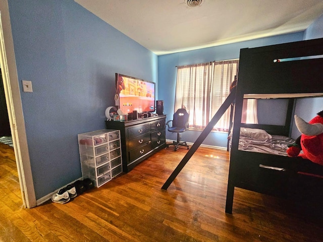 bedroom with baseboards and wood finished floors