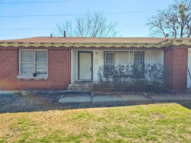 ranch-style home with a front yard, brick siding, and entry steps