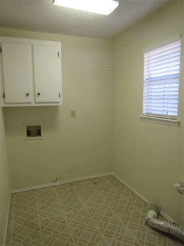 washroom with cabinet space, hookup for a washing machine, baseboards, and a textured ceiling