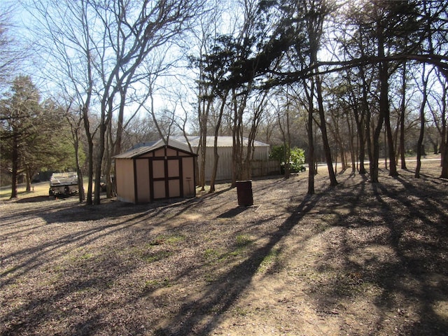 view of yard with a storage shed and an outbuilding