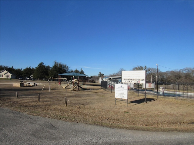 view of yard featuring playground community and fence