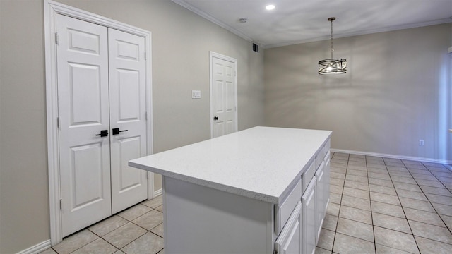 kitchen with a center island, pendant lighting, crown molding, light countertops, and light tile patterned flooring